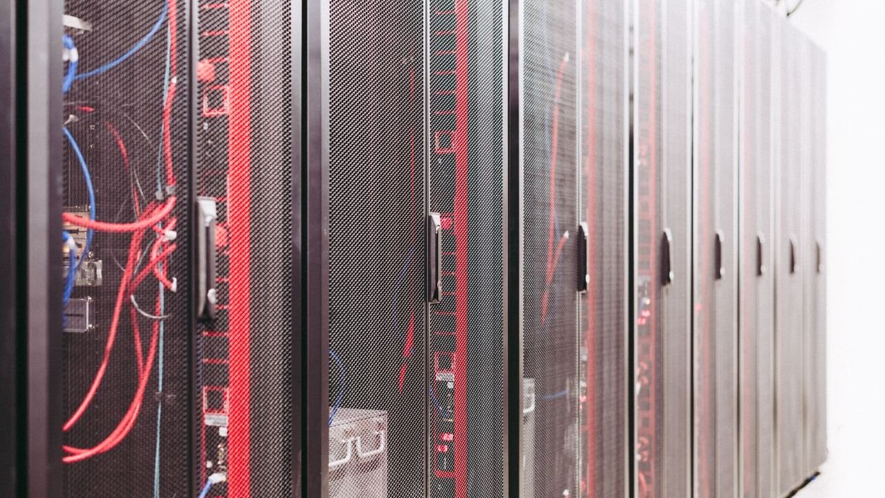 Rows of server racks in a data center with red and black cabling