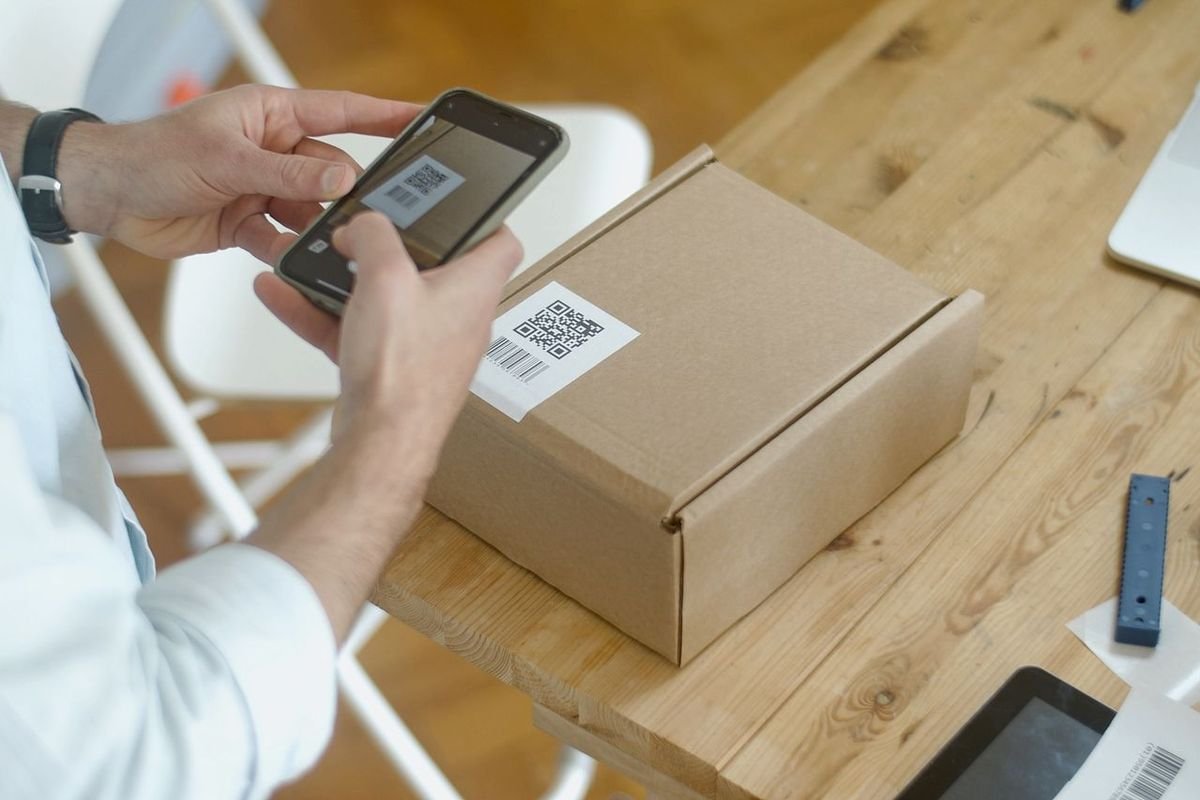 Person scanning a code on a parcel with a smartphone