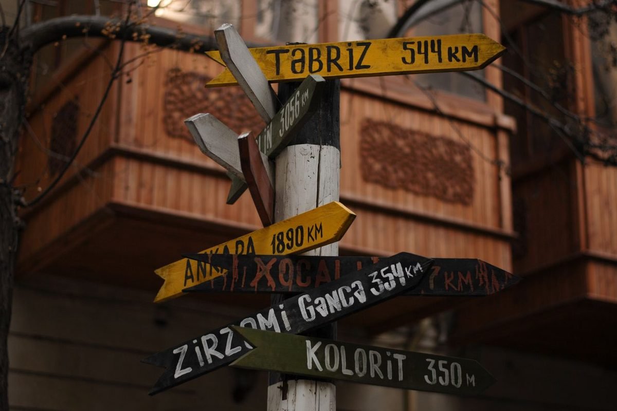 Multi-directional signpost with city names and distances