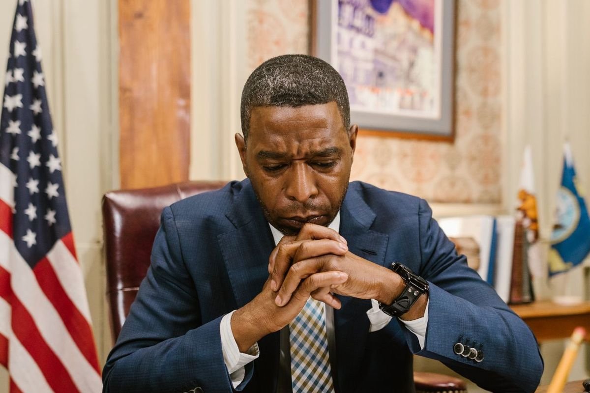 Lawyer in a suit with hands clasped at a desk in an office