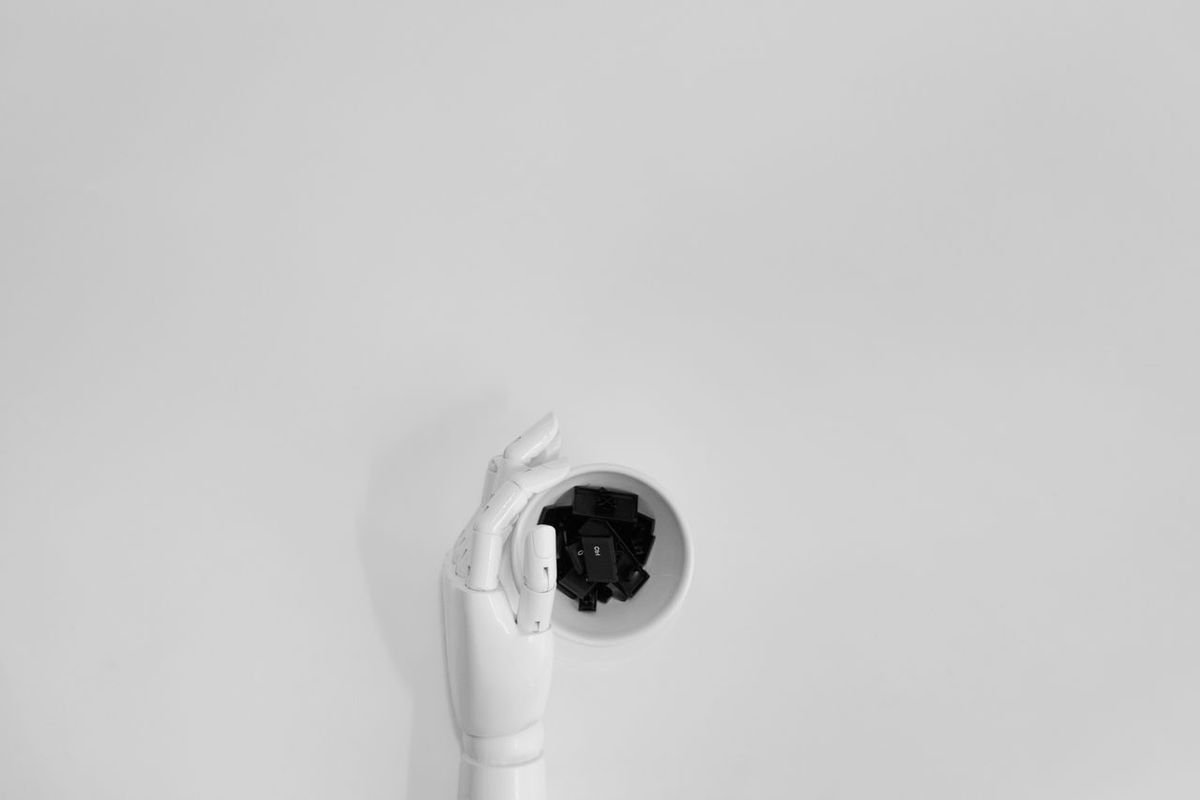 Robotic hand pulling a camera-like lens out of a white wall