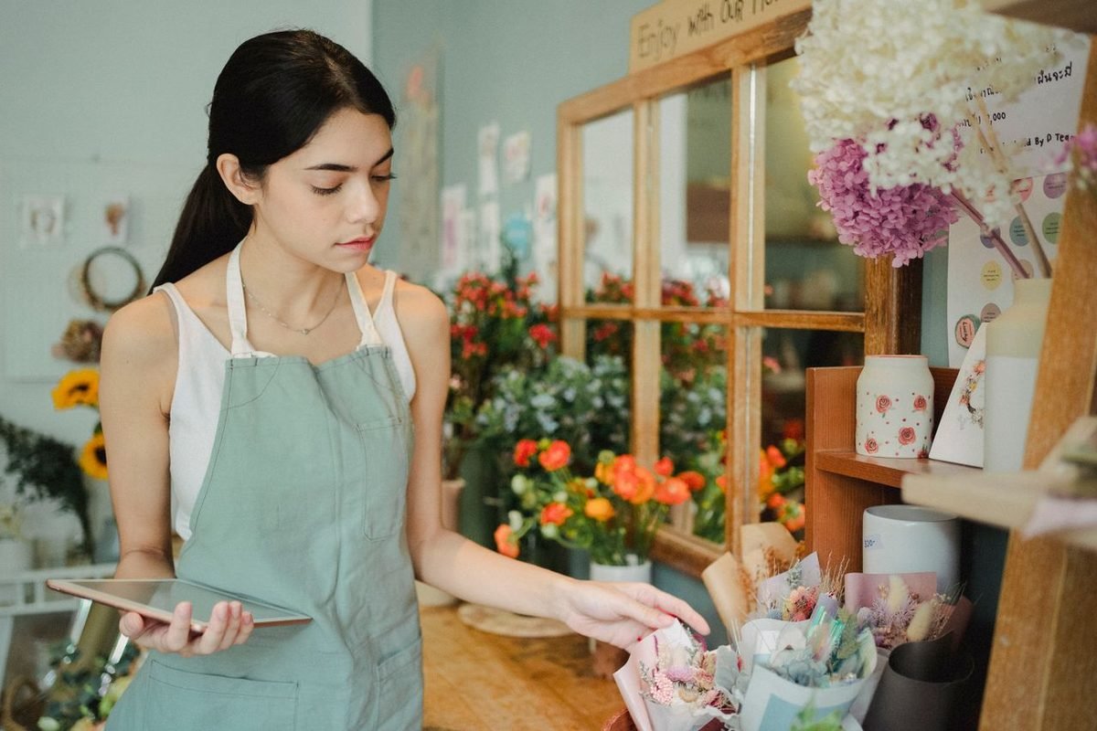 Florist checking an order on a tablet inside her flower shop
