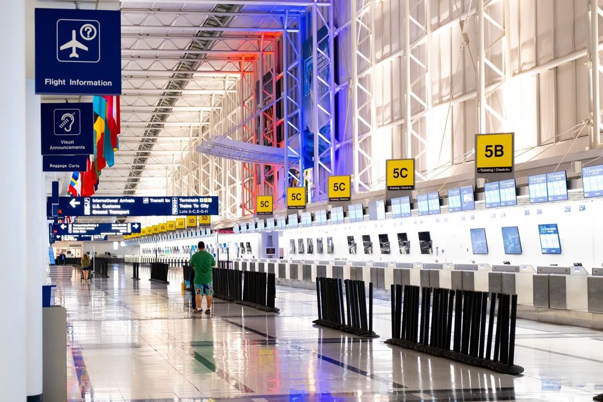 Airport terminal with check-in counters and flags
