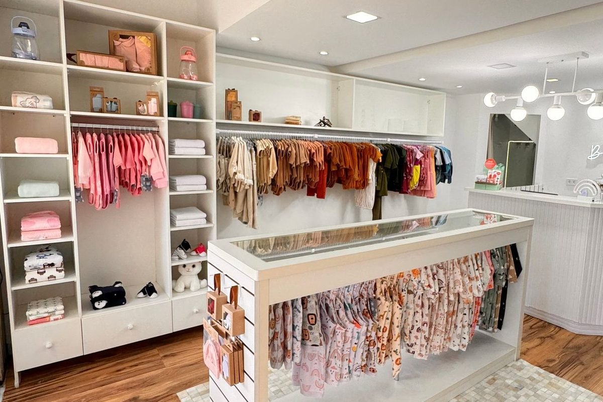 Children's clothing neatly arranged on shelves in a small shop