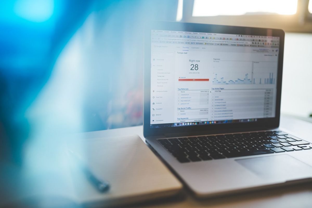 Laptop showing an analytics dashboard with a line chart on a desk