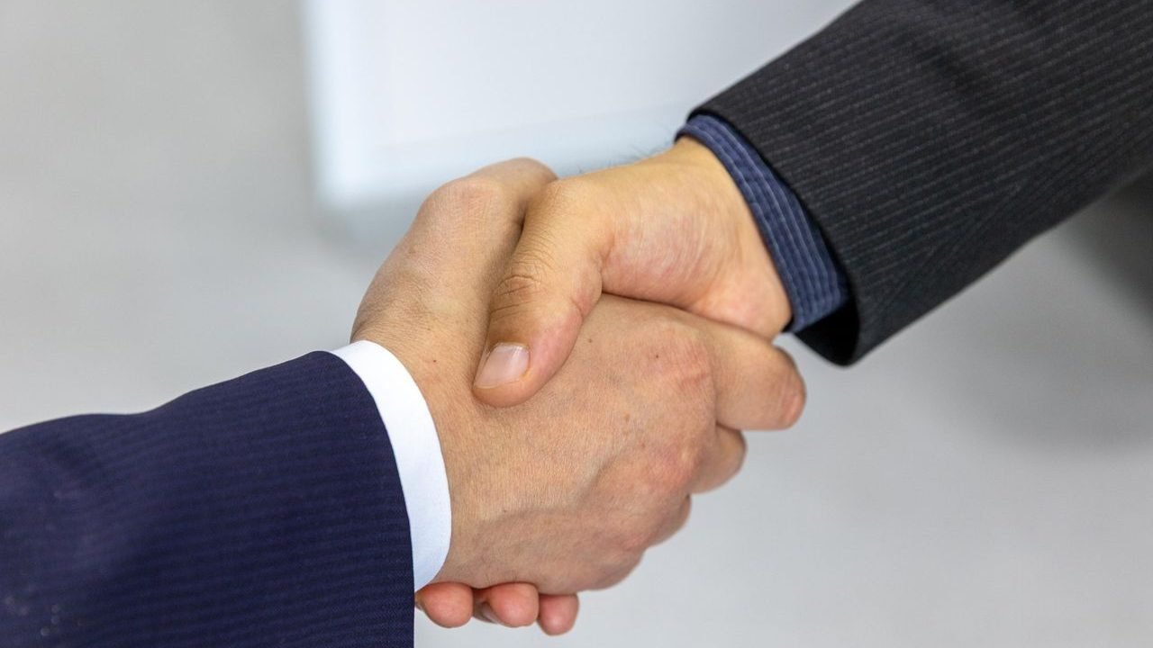 Two business people shaking hands at a meeting