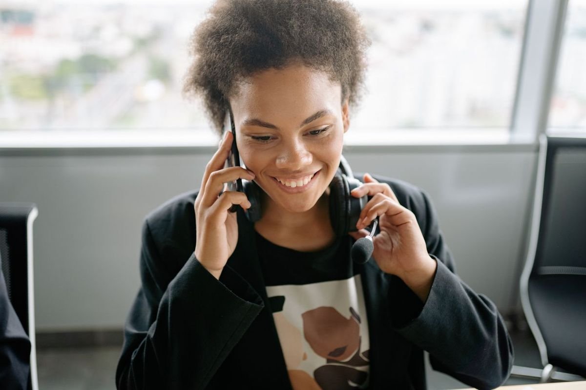 Smiling woman taking a call on a mobile phone in an office