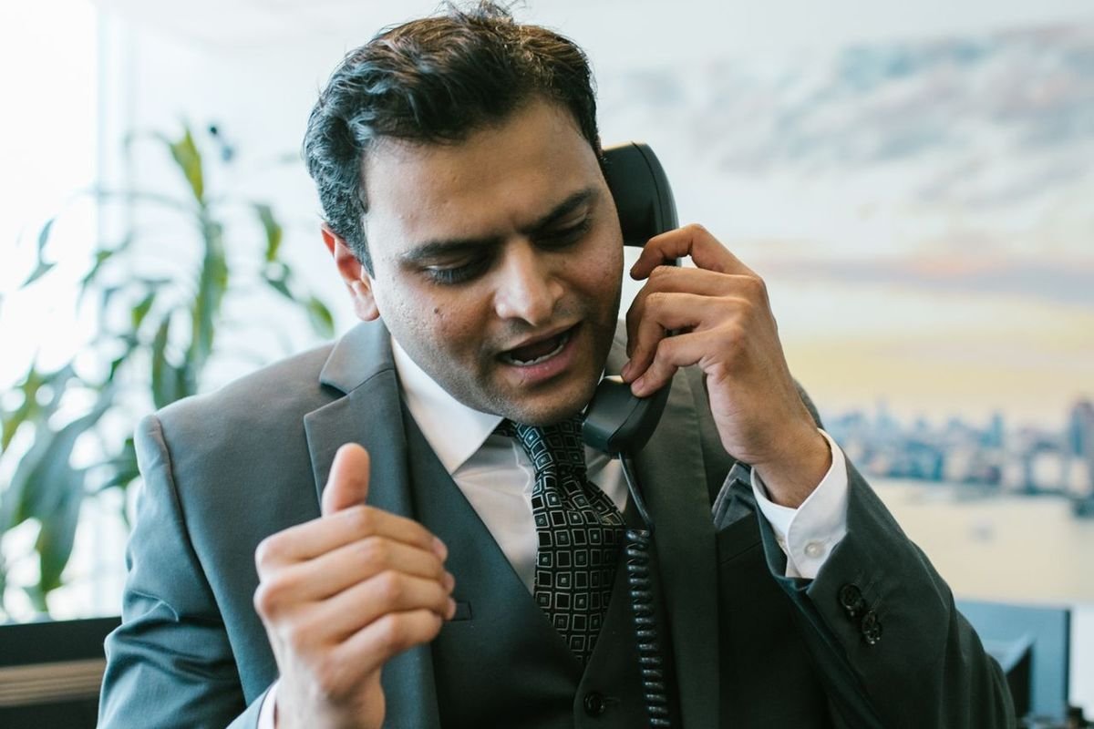 Businessman speaking on a desk phone in a modern office