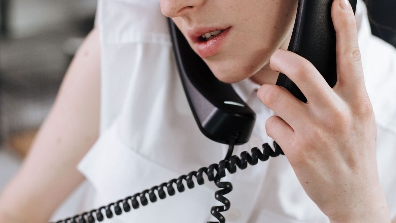 Woman talking on a landline phone at an office desk