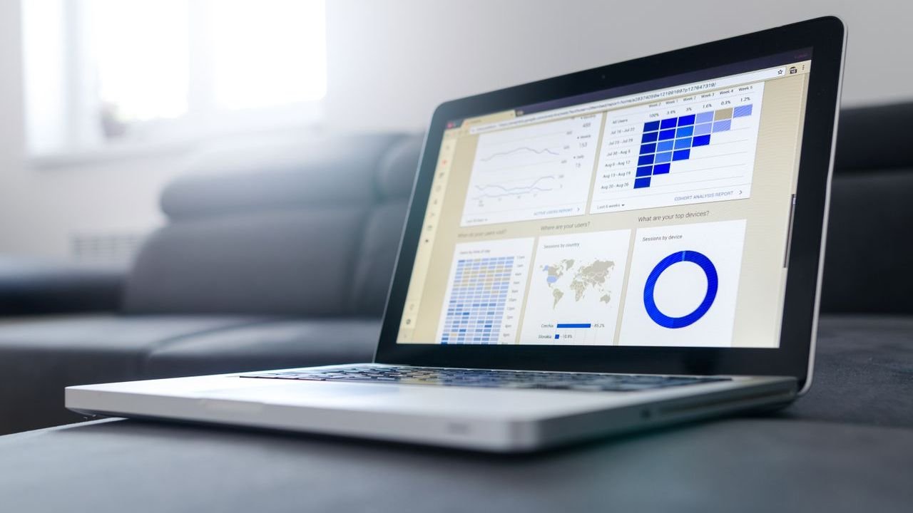 Laptop on a table showing analytics charts and dashboards