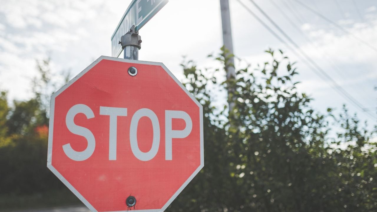 Red stop sign against trees and sky