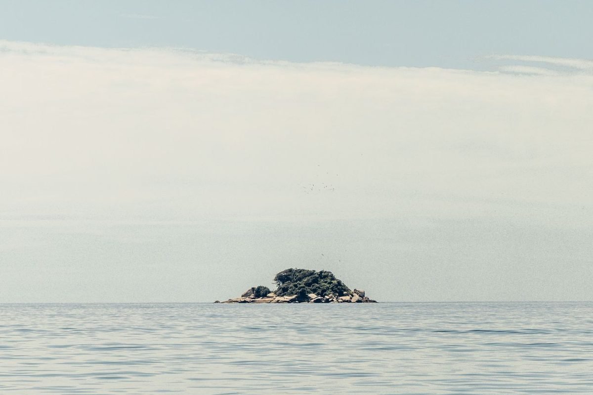 Rocky island alone in the sea on the horizon