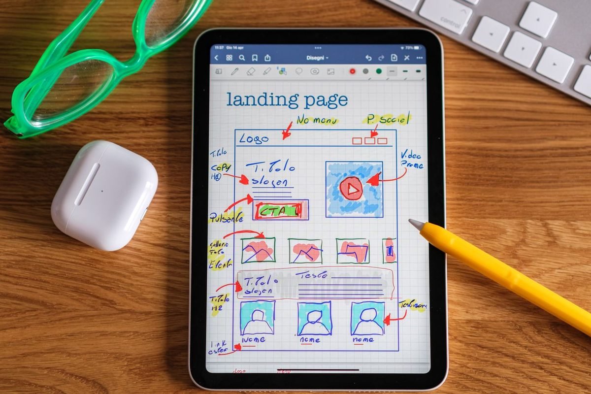 Tablet showing a hand-drawn landing page layout with annotations