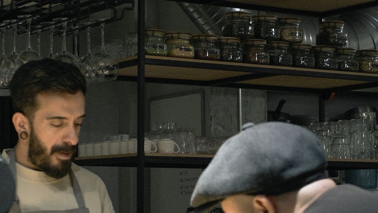 Barista and customer talking at a cafe counter