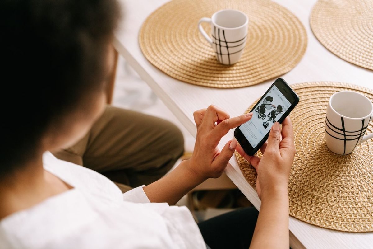 Person shopping online on a smartphone at a table