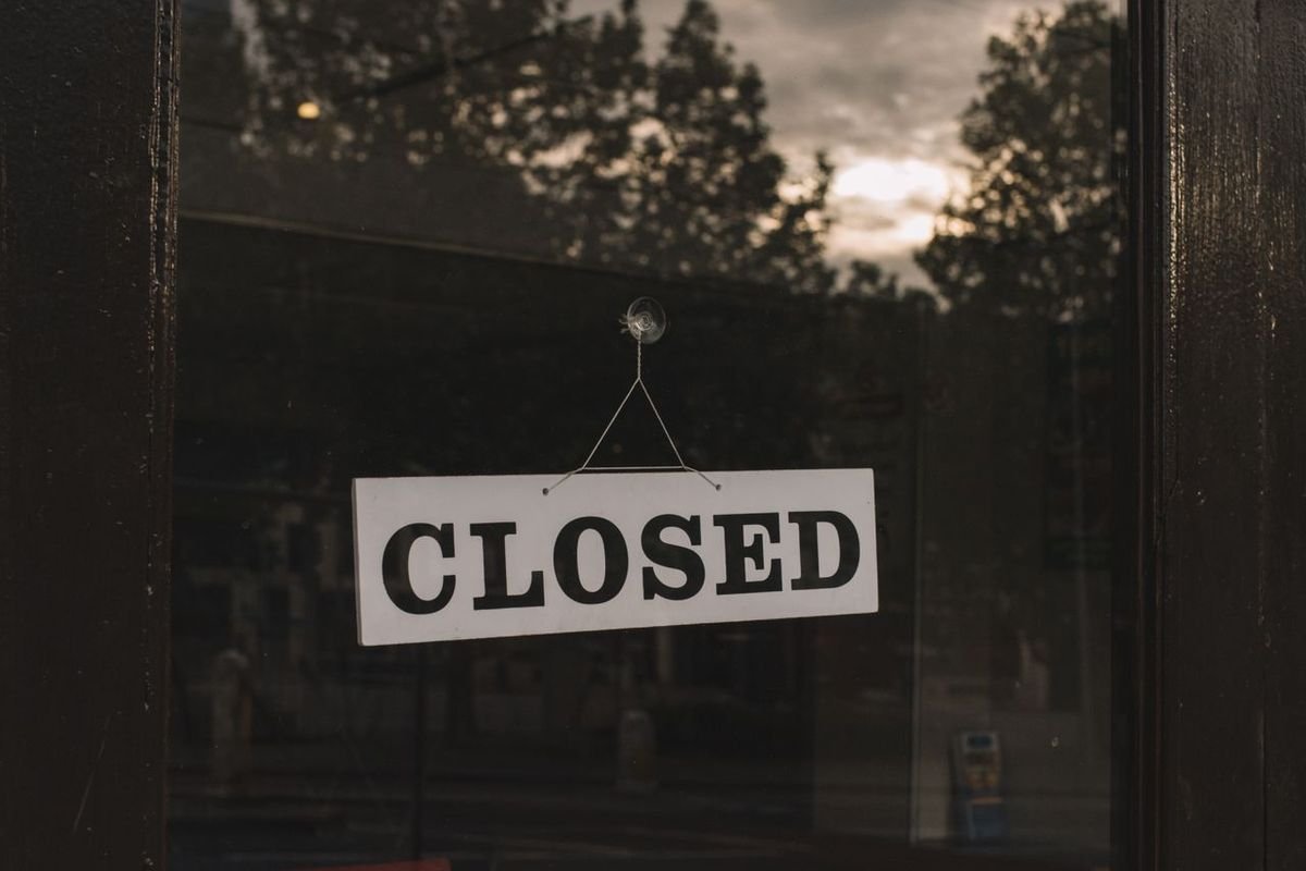 Closed sign hanging on a shop glass door