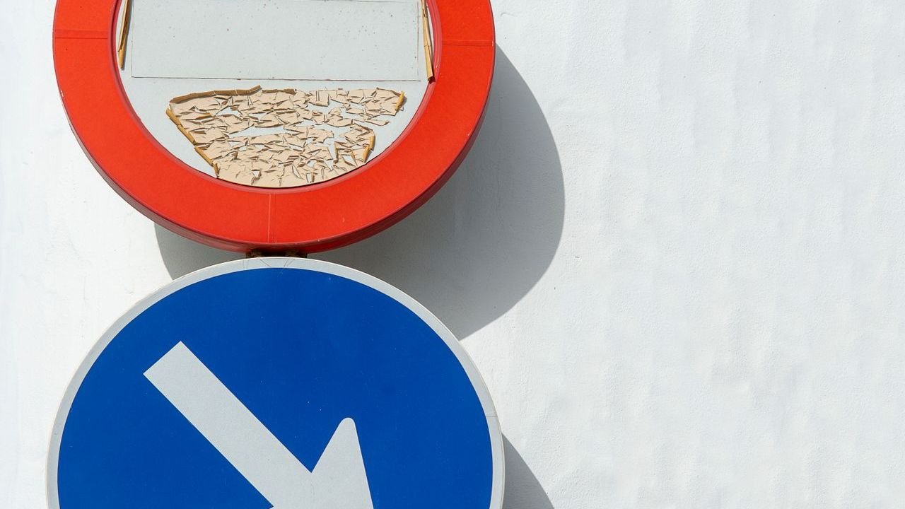 Two traffic signs with arrows pointing in different directions