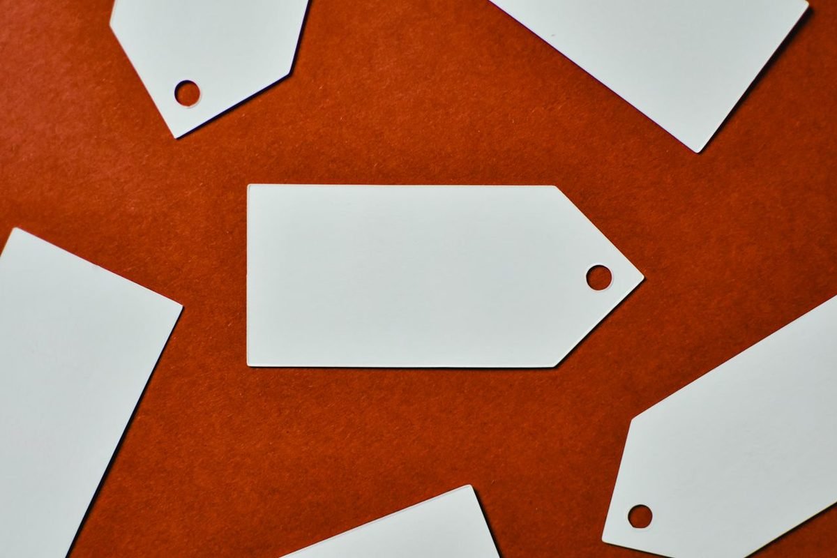 White blank paper tags on a red surface