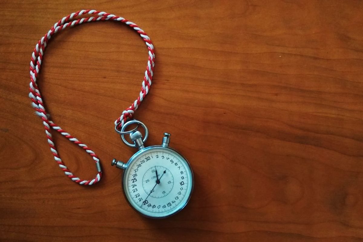 Antique stopwatch with a braided cord on a wooden table