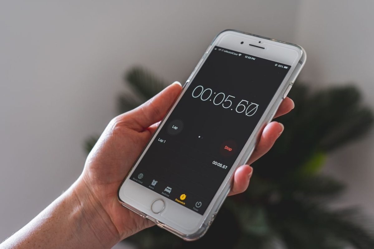 Hand holding a smartphone showing a running stopwatch