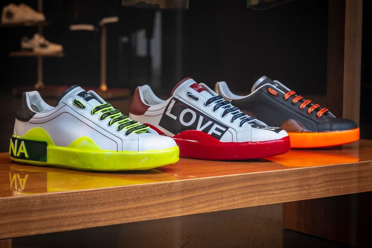 Colorful sneakers lined up on a wooden shelf in a shop