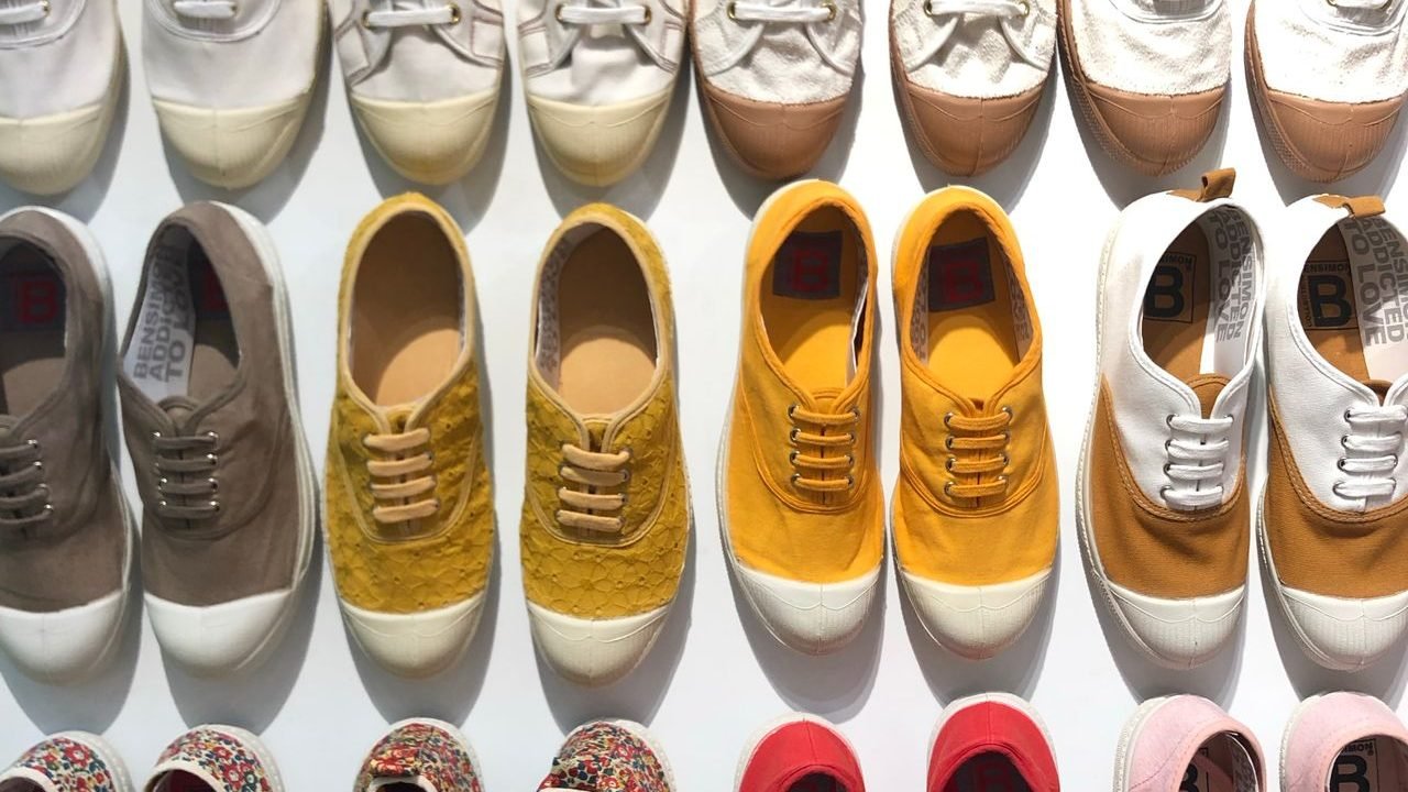 Rows of canvas shoes in many colors on a wall display